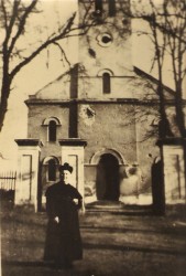 Ks. Kwastek przed zniszczonym podczas II wojny światowej kościołem